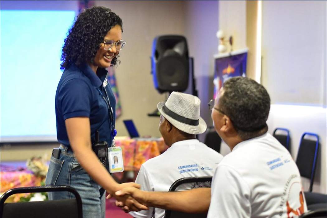 Participantes do Comunidades Sustentáveis se cumprimentam durante um encontro entre comunidades e parceiros